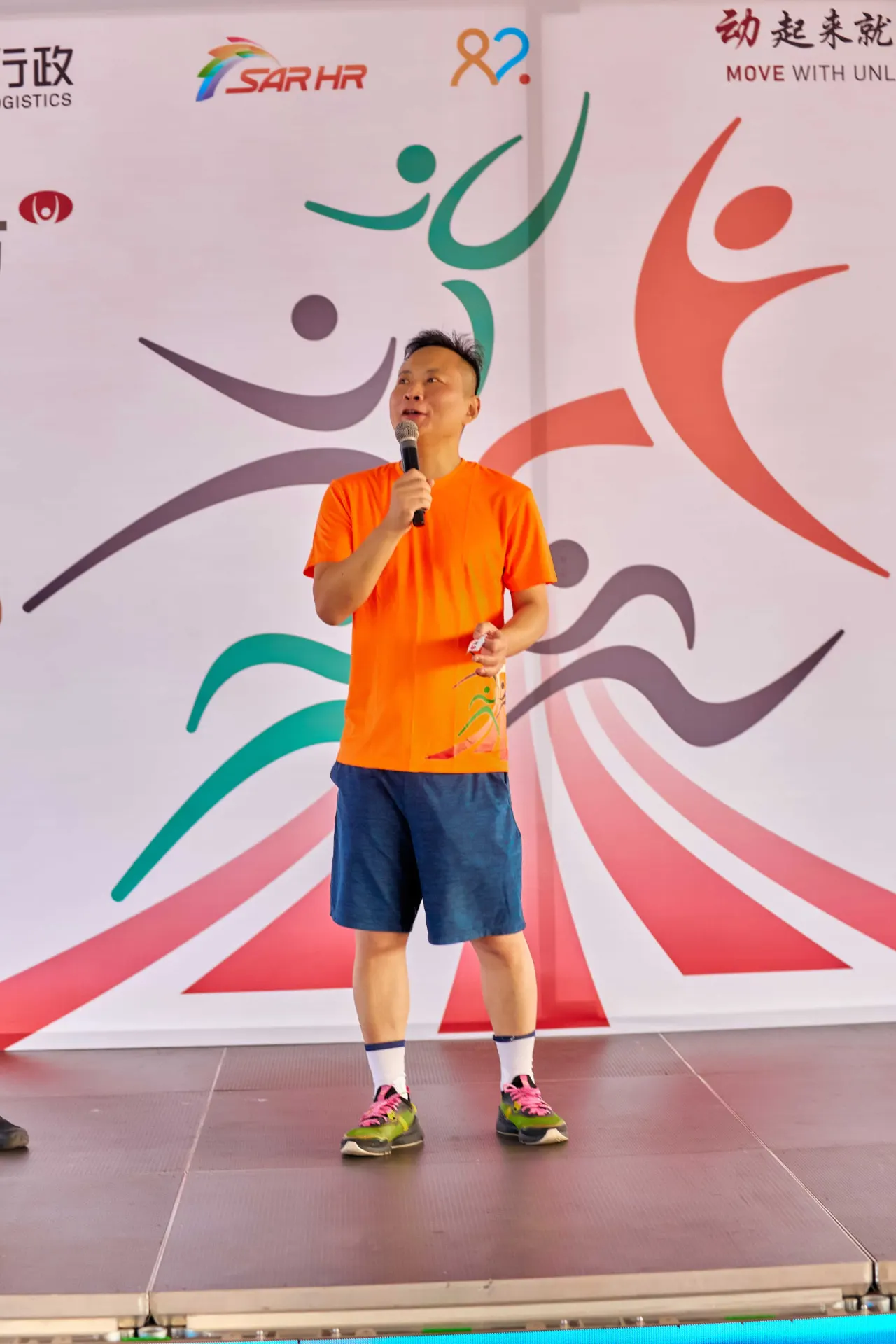 Speaker addressing the crowd from the Huawei Fitness Festival stage